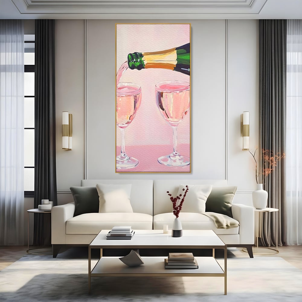 Tablou canvas cu pictura cu sticla si pahare de sampanie roz, in rama de aluminiu auriu, pe perete intr-un living